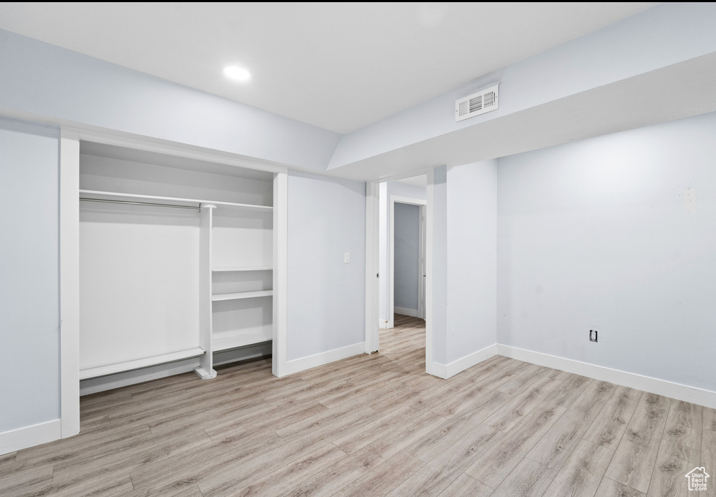Unfurnished bedroom with wood finished floors, a closet, baseboards, and recessed lighting
