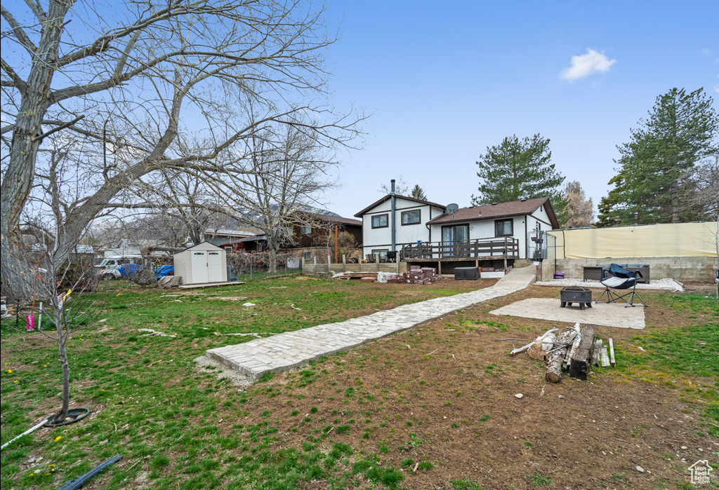 View of yard with a fire pit, a deck, and a patio area