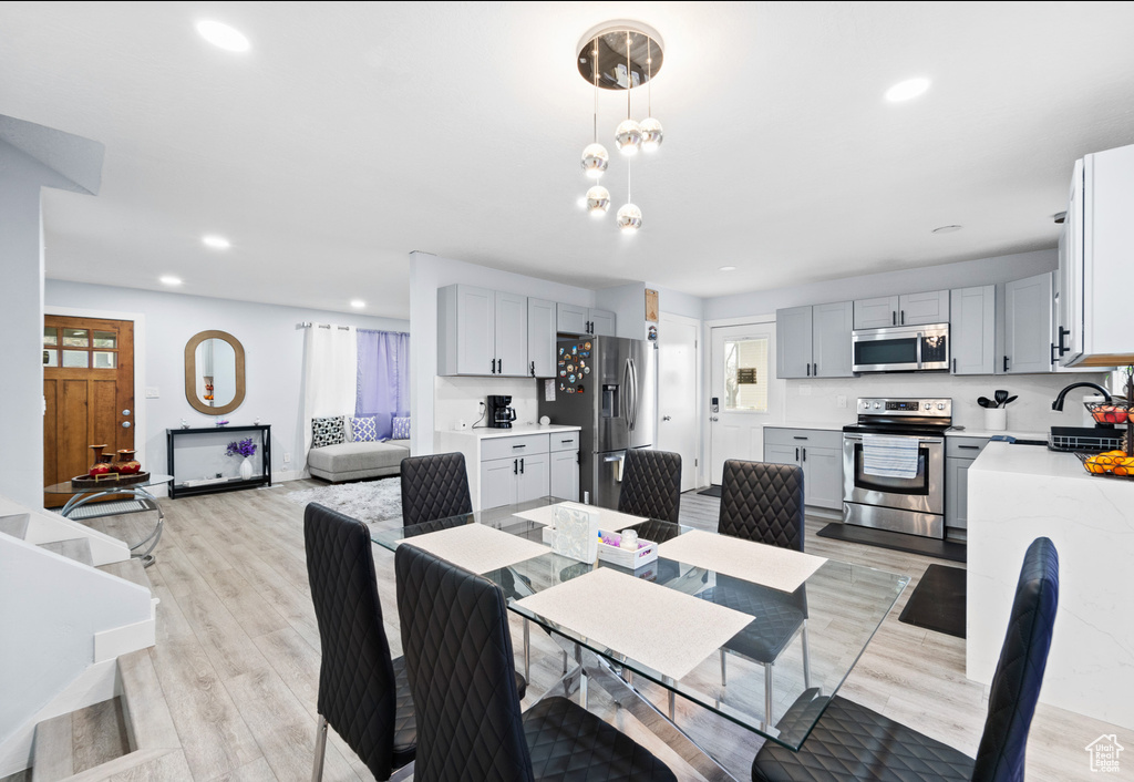 Dining area with recessed lighting and light wood-style floors