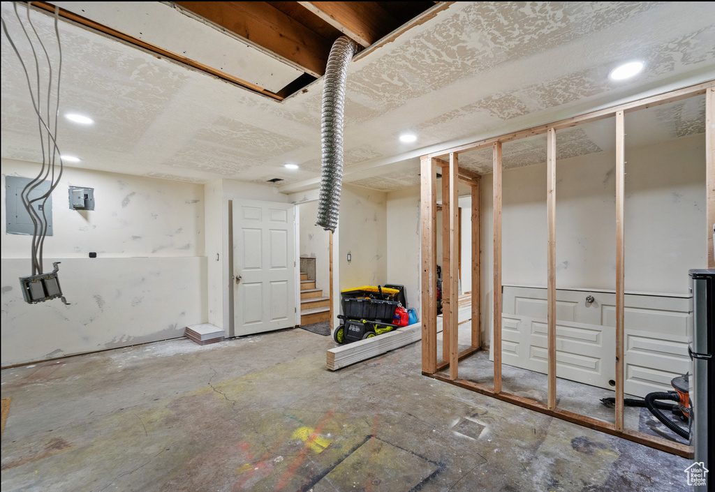 Unfinished below grade area with recessed lighting and stairway