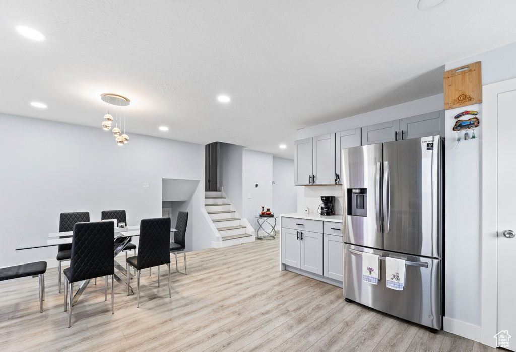 Kitchen featuring stainless steel fridge, light wood finished floors, gray cabinets, recessed lighting, and light countertops