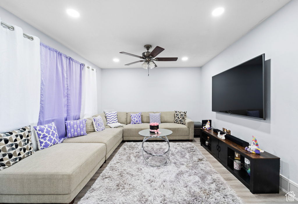 Living area featuring light wood-style floors, a ceiling fan, and recessed lighting
