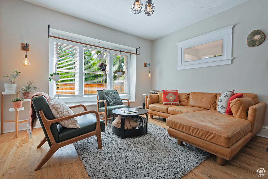 Living area with light wood-style floors and a chandelier
