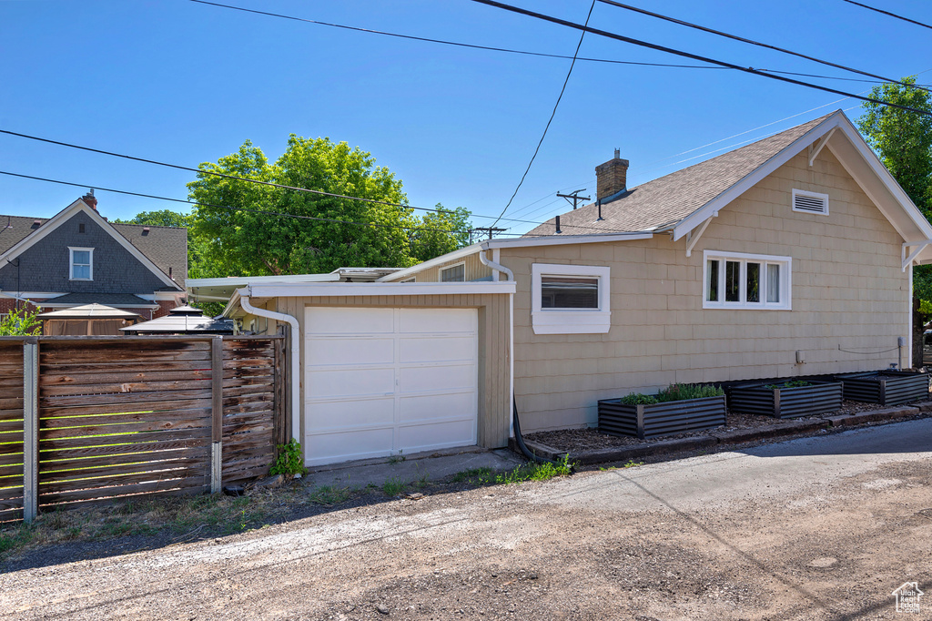 View of home's exterior with a chimney and roof with shingles