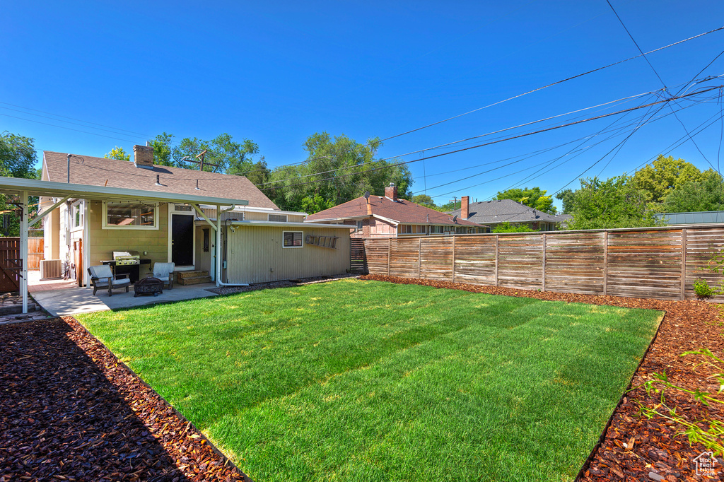 View of yard with entry steps and a patio