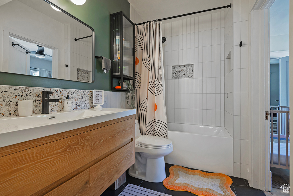 Bathroom with shower / bath combo, vanity, toilet, backsplash, and tile patterned flooring