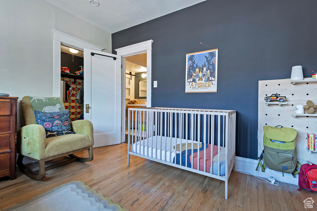Bedroom with hardwood / wood-style floors and baseboards