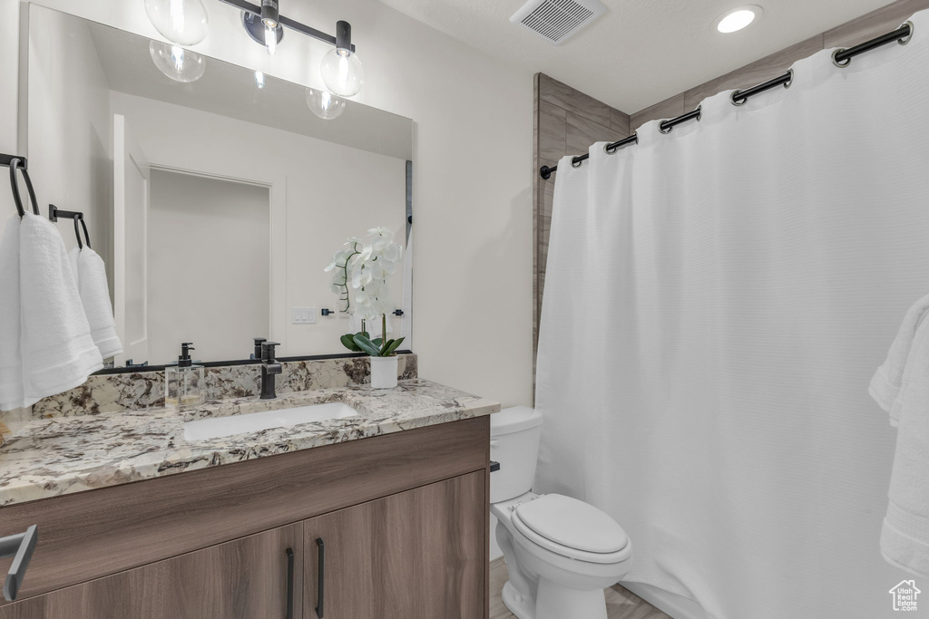 Full bath with vanity, toilet, and a shower with curtain