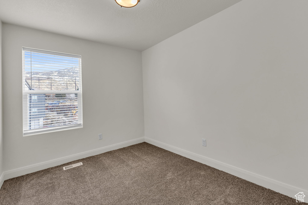 Carpeted empty room featuring baseboards