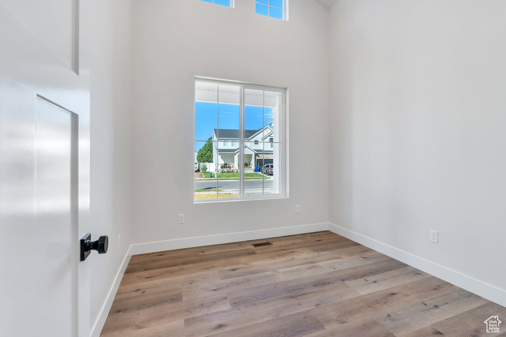 Spare room with wood finished floors and a high ceiling