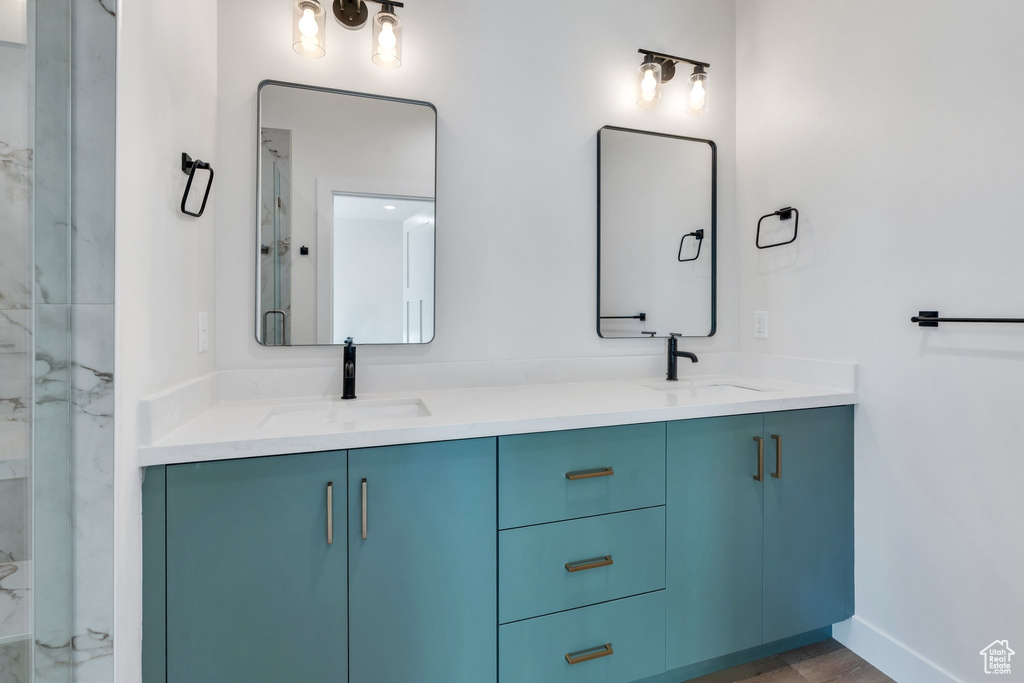 Full bathroom with double vanity and baseboards