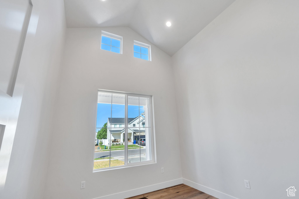 Spare room with wood finished floors and lofted ceiling