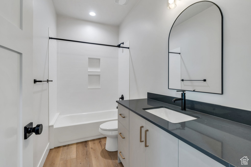 Full bath featuring vanity, wood finished floors, tub / shower combination, and recessed lighting