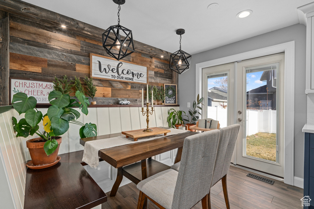 Dining space featuring wooden walls, recessed lighting, and wood finished floors