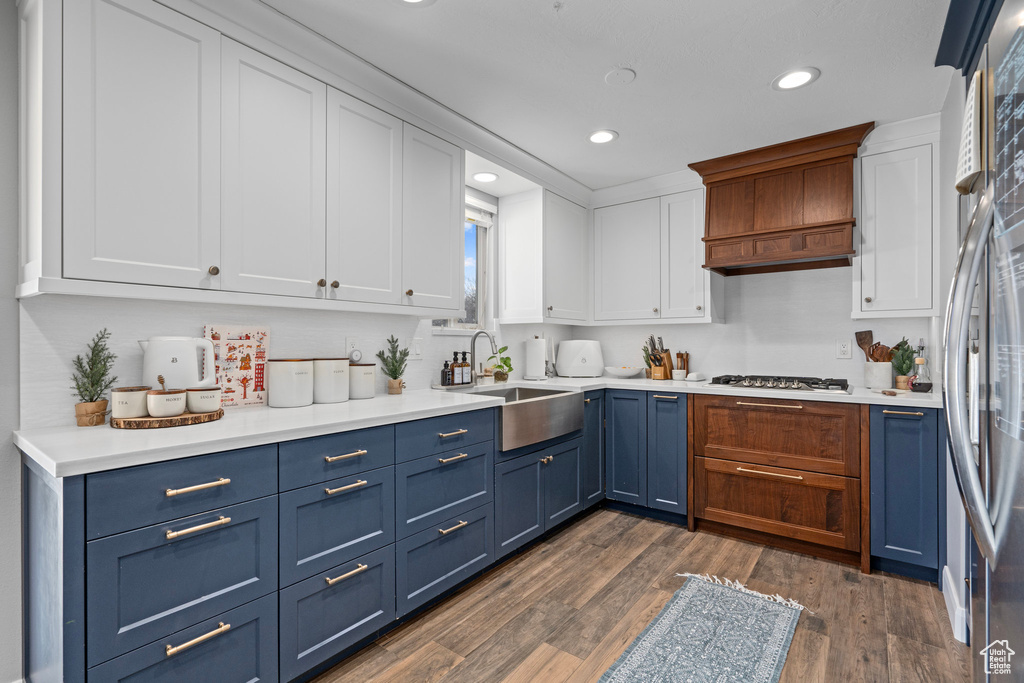Kitchen featuring blue cabinetry, a sink, white cabinets, recessed lighting, and light countertops