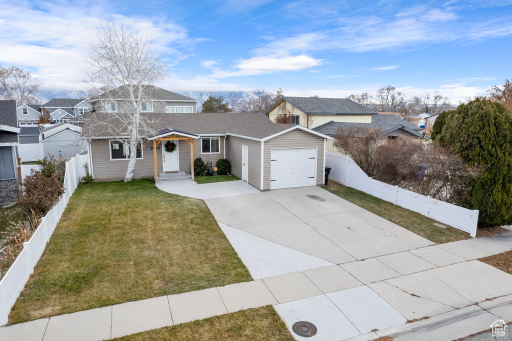 Traditional-style house featuring a garage, concrete driveway, and a shingled roof