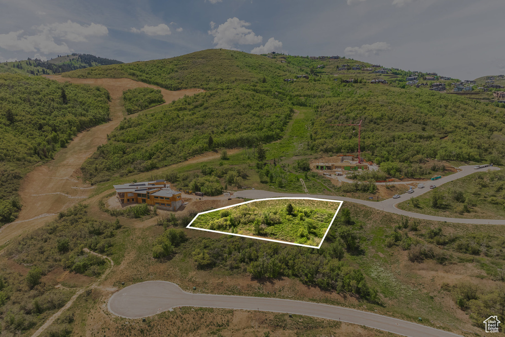Aerial overview of property's location with property parcel outlined and a mountainous background