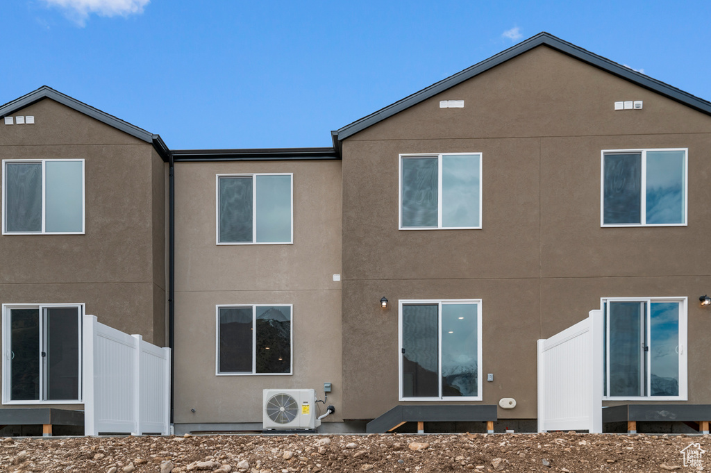 Rear view of house featuring a cooling unit and stucco siding
