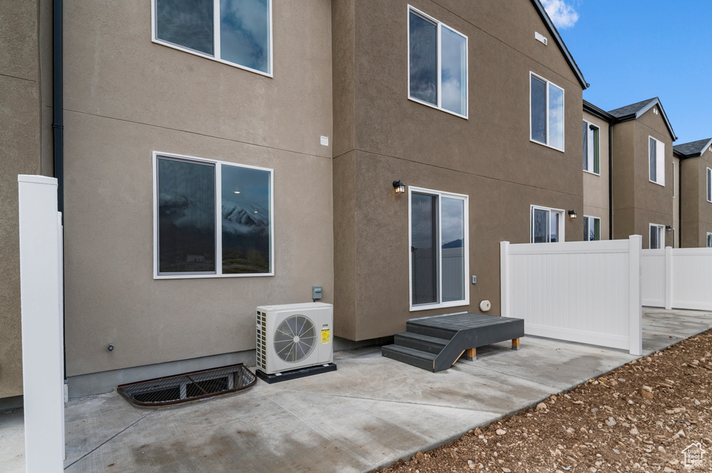 Back of house with a cooling unit, a patio area, and stucco siding