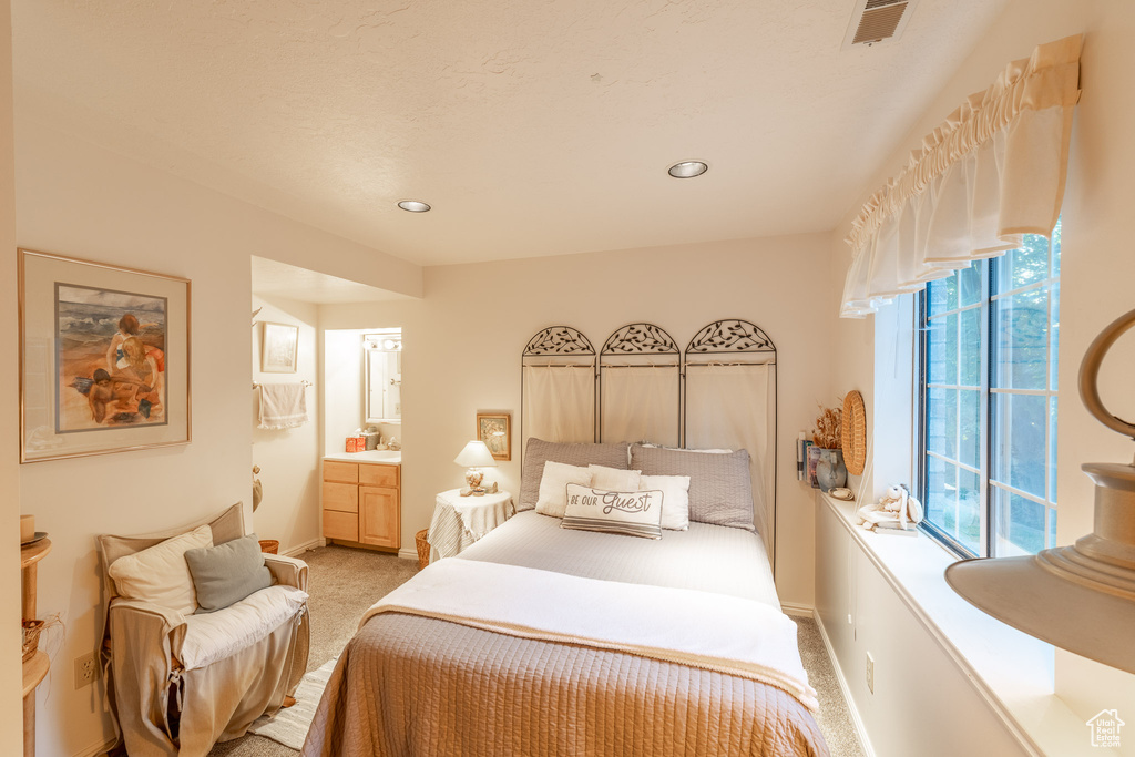 Bedroom featuring light carpet, baseboards, recessed lighting, and ensuite bathroom