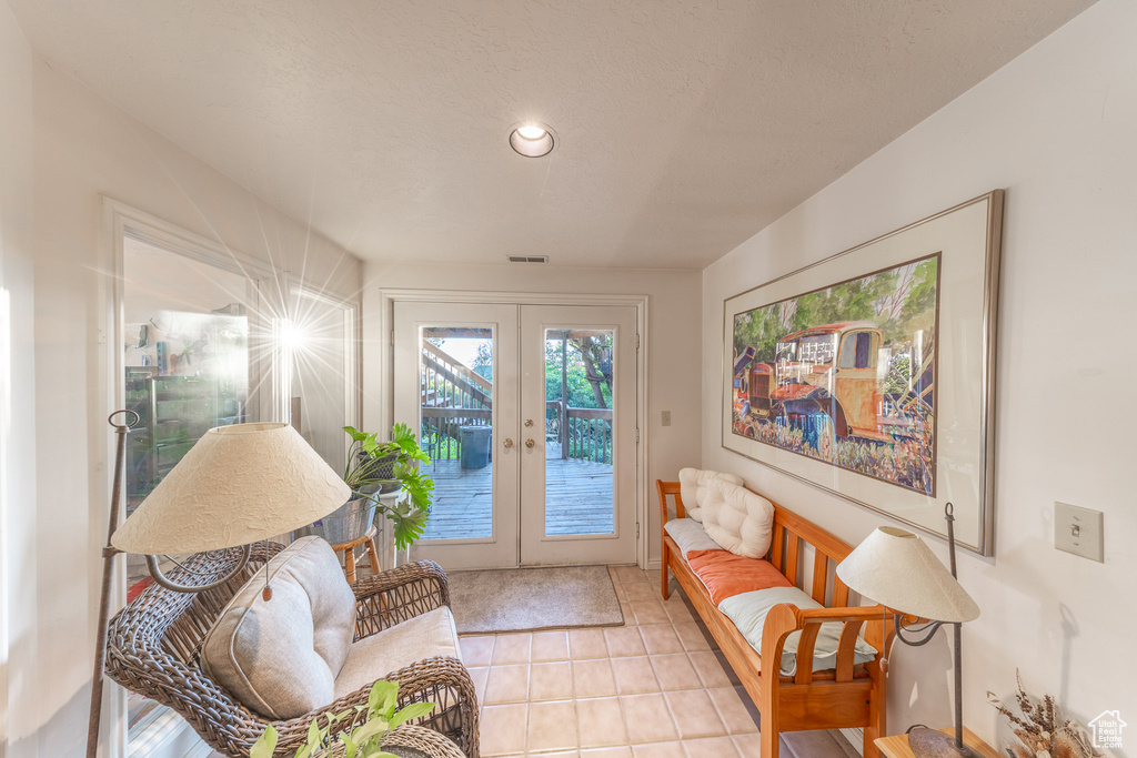 Sitting room with french doors, light tile patterned flooring, and recessed lighting