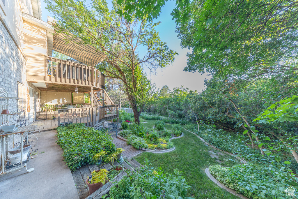 View of yard with a wooden deck and stairway