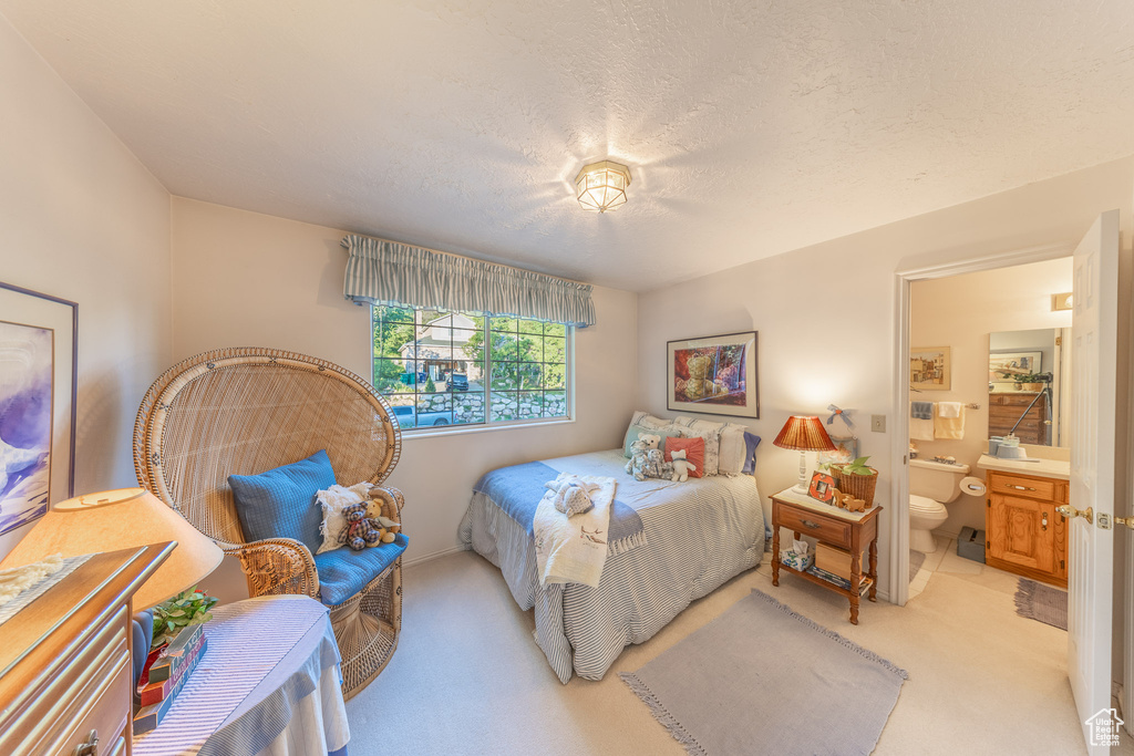 Bedroom with light carpet and ensuite bath