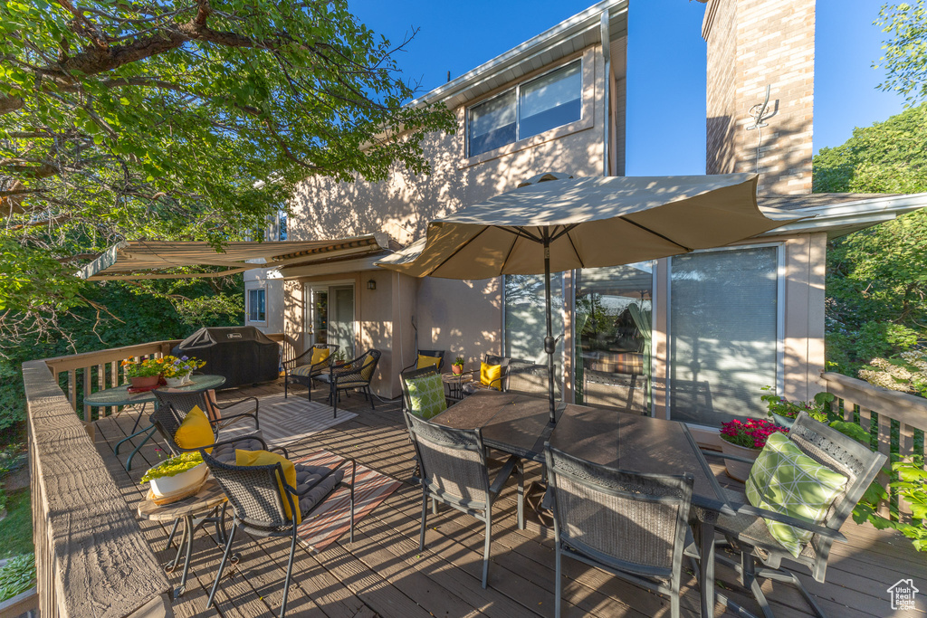 Deck with outdoor dining area and a grill