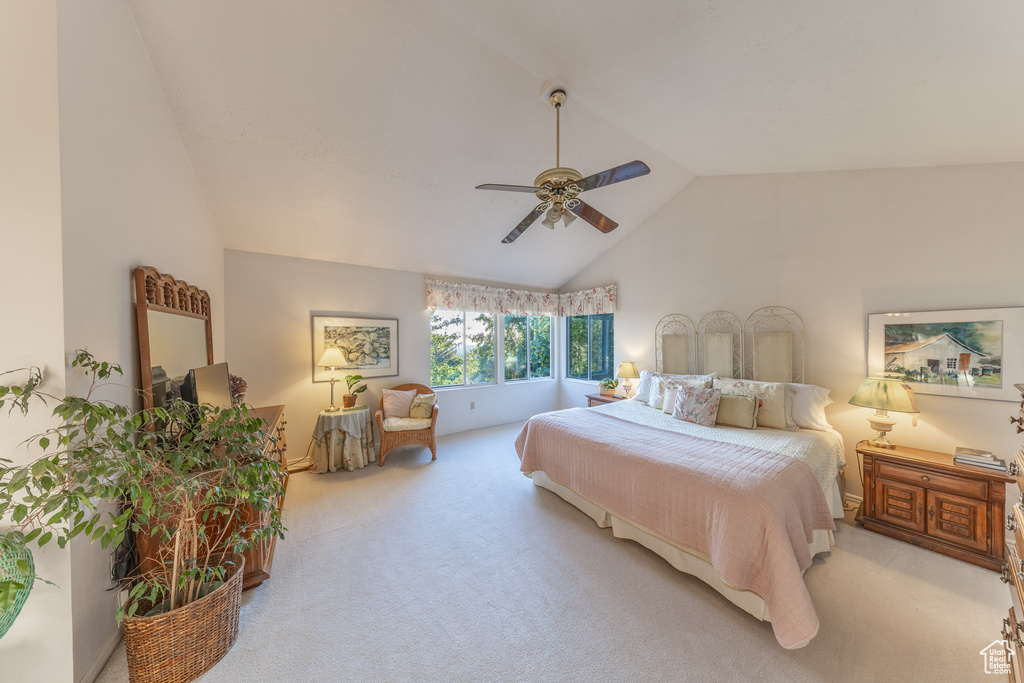 Bedroom with light carpet, a ceiling fan, and high vaulted ceiling