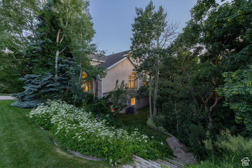 View of side of property featuring a yard and stucco siding