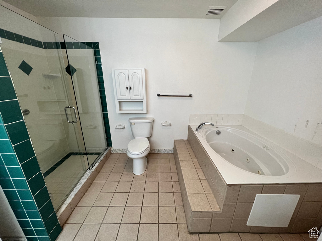 Full bathroom featuring a shower stall, a tub with jets, toilet, tile patterned floors, and baseboards