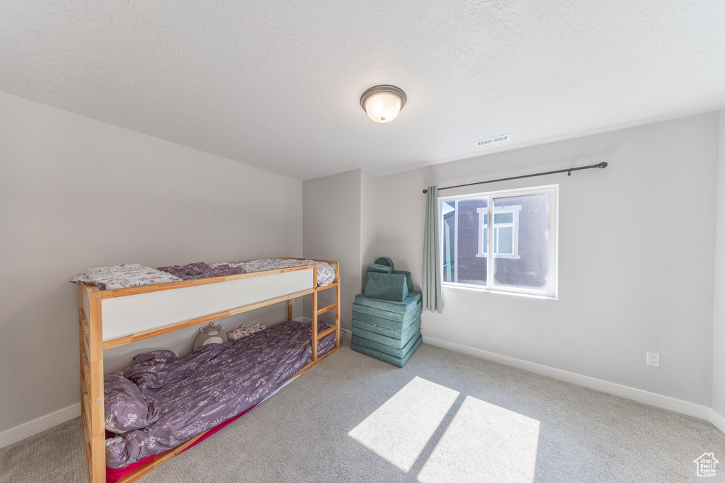 Carpeted bedroom with baseboards and a textured ceiling