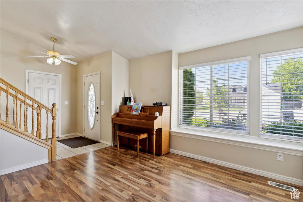 Entryway with wood finished floors, baseboards, and stairway