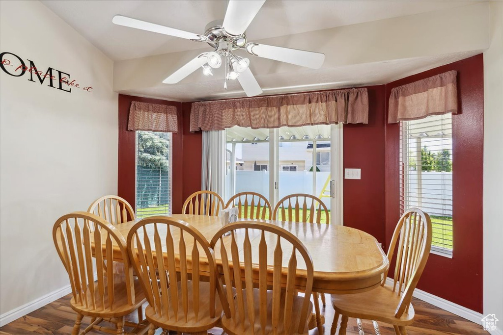 Dining area with baseboards, wood finished floors, healthy amount of natural light, and a ceiling fan