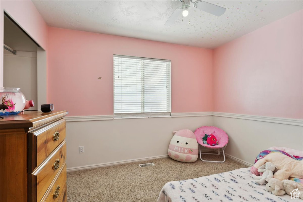 Carpeted bedroom with baseboards, a ceiling fan, and a closet
