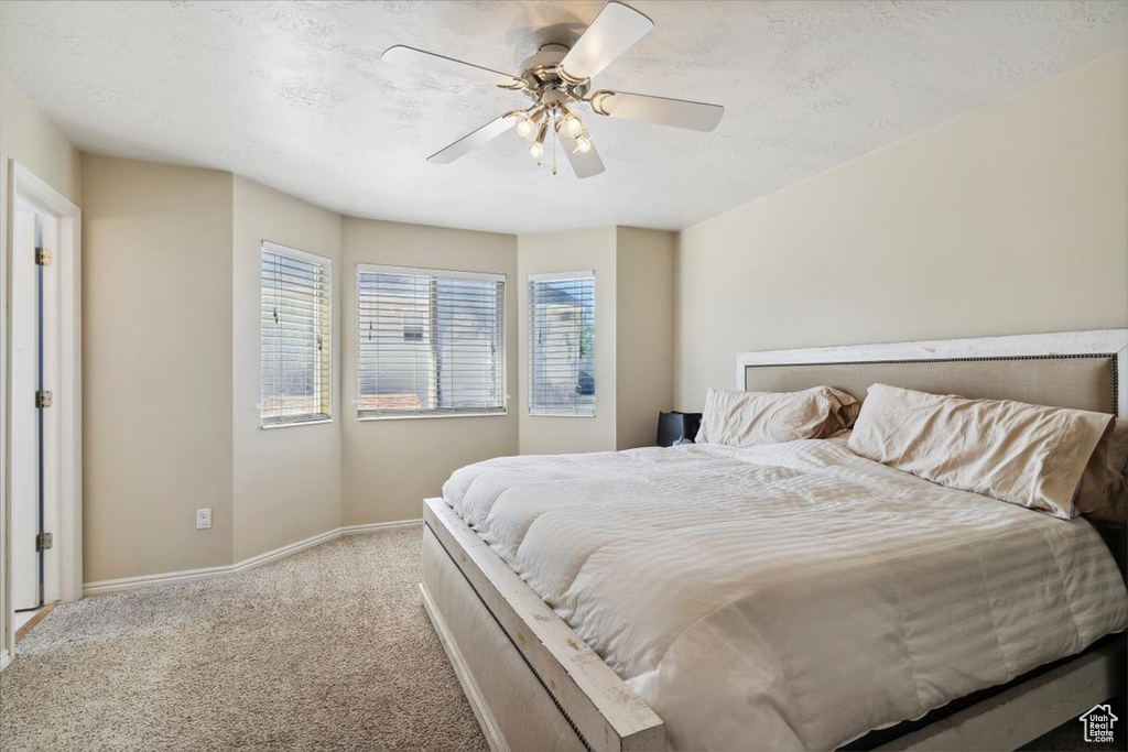 Carpeted bedroom with baseboards and a ceiling fan