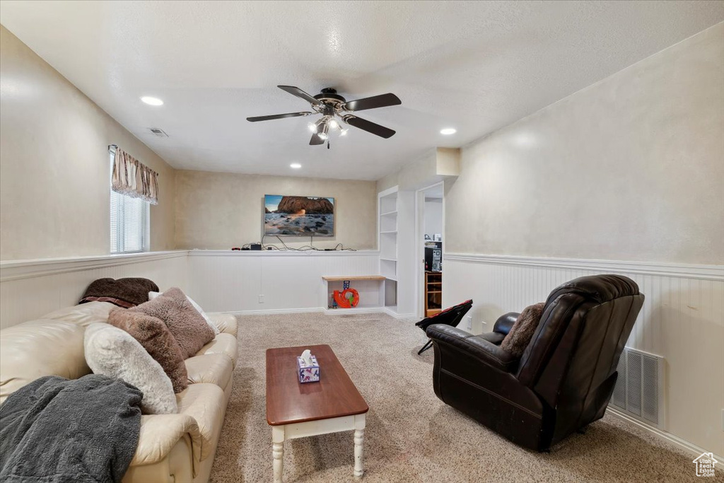 Living room featuring ceiling fan, wainscoting, carpet flooring, recessed lighting, and built in features