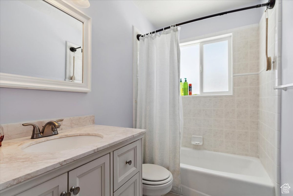 Full bathroom with vanity, toilet, and shower / bath combo