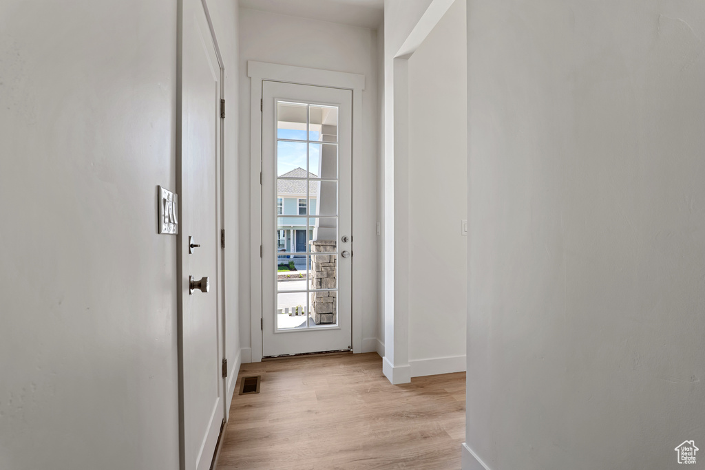 Doorway to outside with baseboards and light wood-style flooring