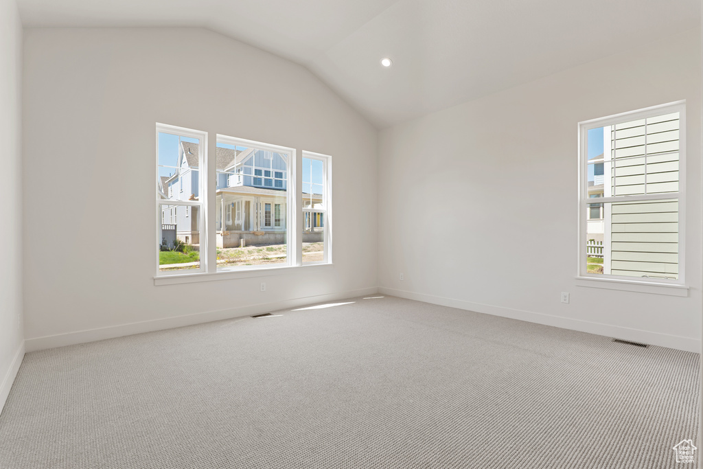 Carpeted spare room with vaulted ceiling, baseboards, and recessed lighting