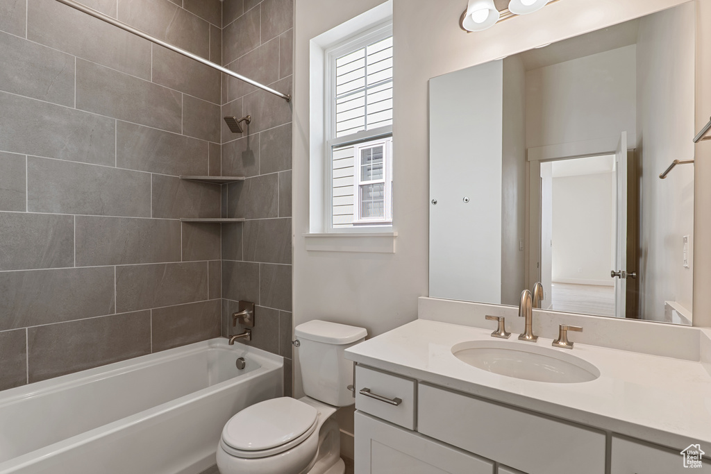 Full bath with toilet, plenty of natural light, vanity, and shower / washtub combination