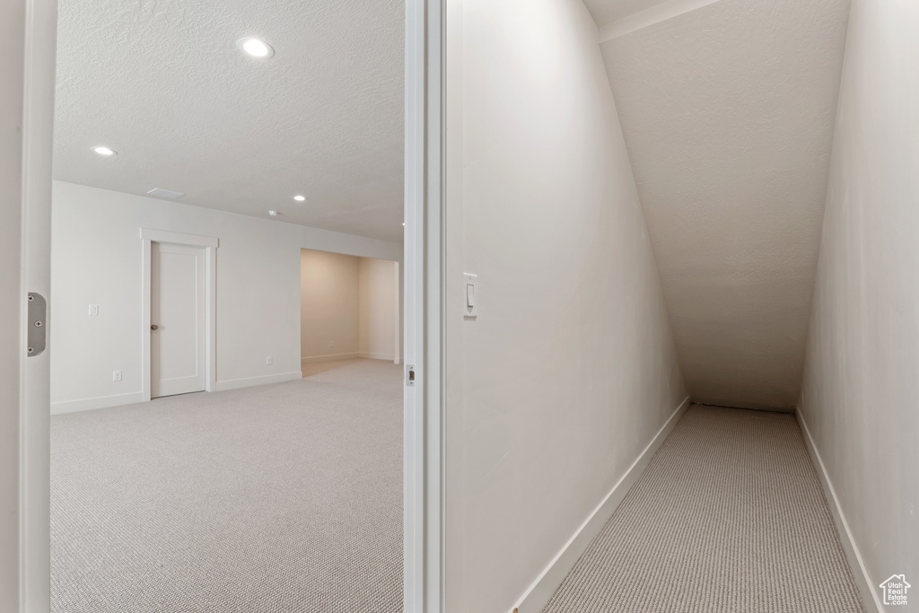 Hallway featuring carpet, recessed lighting, baseboards, and a textured ceiling