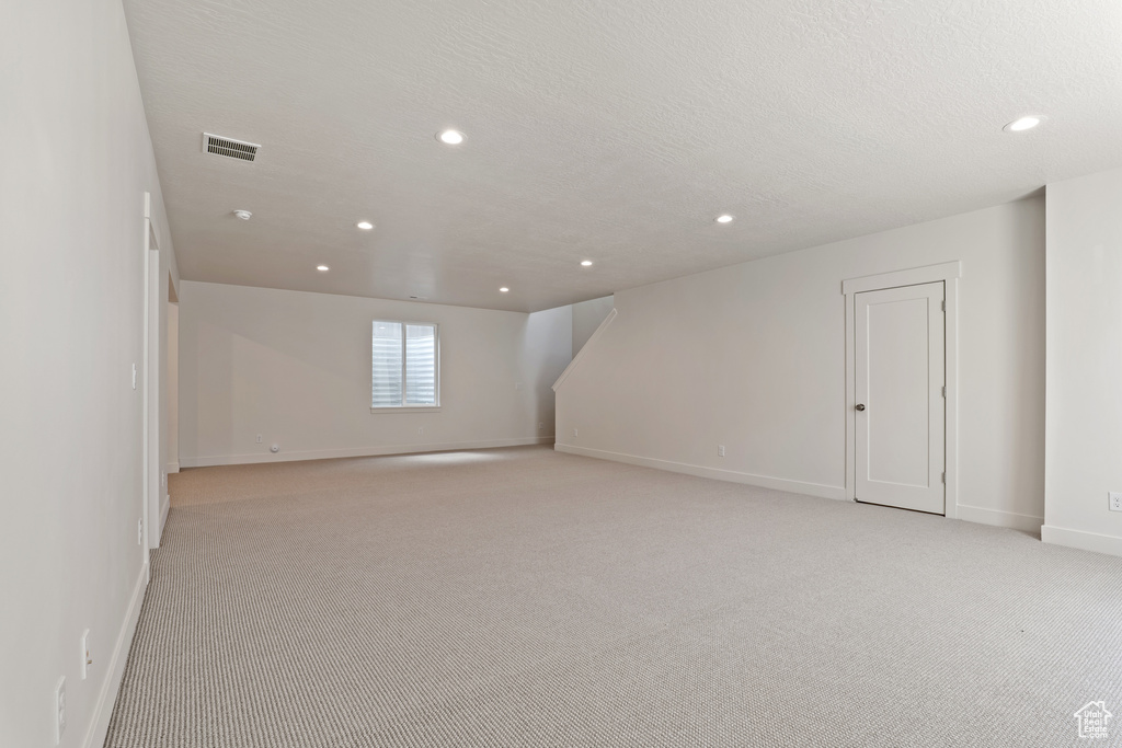 Below grade area with light carpet, baseboards, and recessed lighting