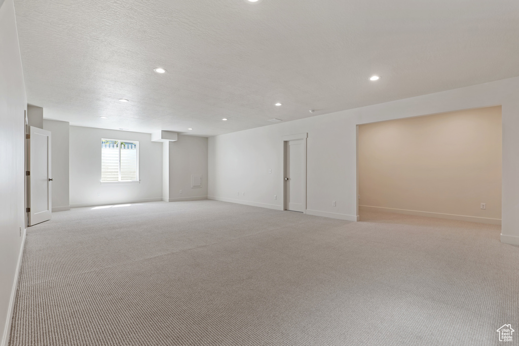 Basement with baseboards, light carpet, and recessed lighting