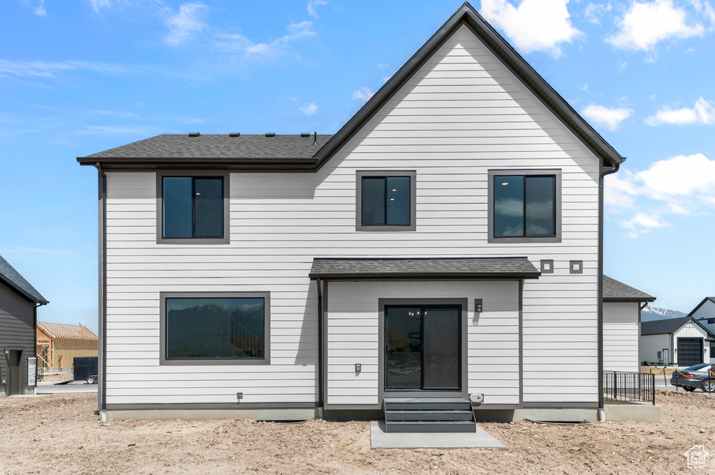 Rear view of property with a shingled roof and entry steps