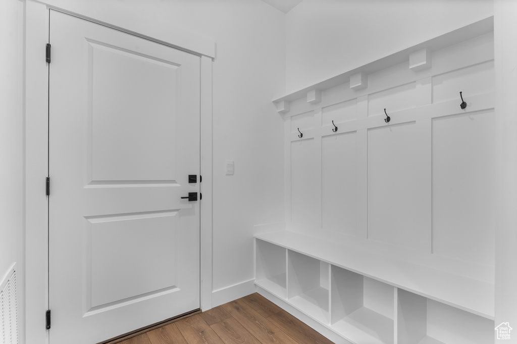 Mudroom featuring dark wood-style flooring and baseboards