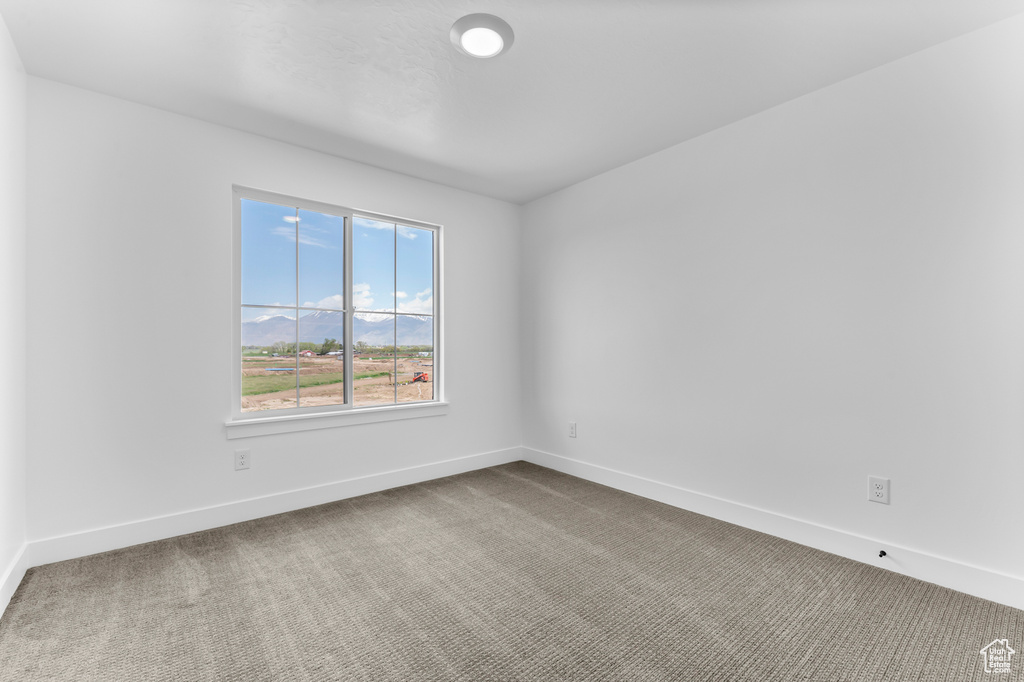 Carpeted empty room with baseboards