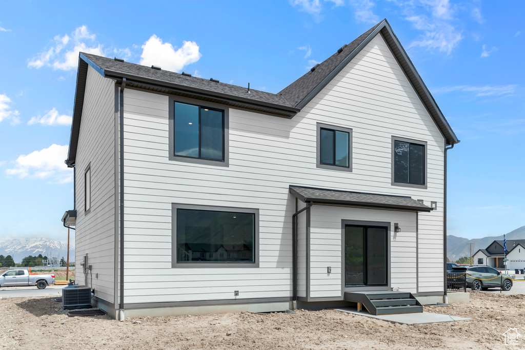 Rear view of house with a mountain view and central AC