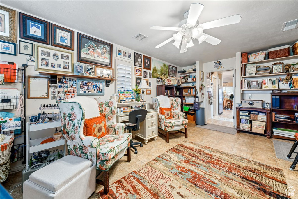 Sitting room with a desk and ceiling fan