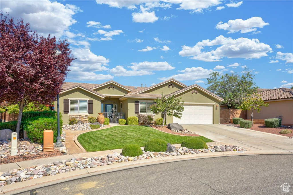 Ranch-style home with a garage, stucco siding, driveway, and a tile roof